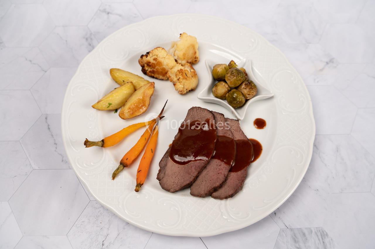 Location salle Donceel (Liège) - Château de Limont #15 Assiette contenant des tranches de viande avec sauce, carottes, pommes de terre, choux de Bruxelles et chou-fleur rôti.
