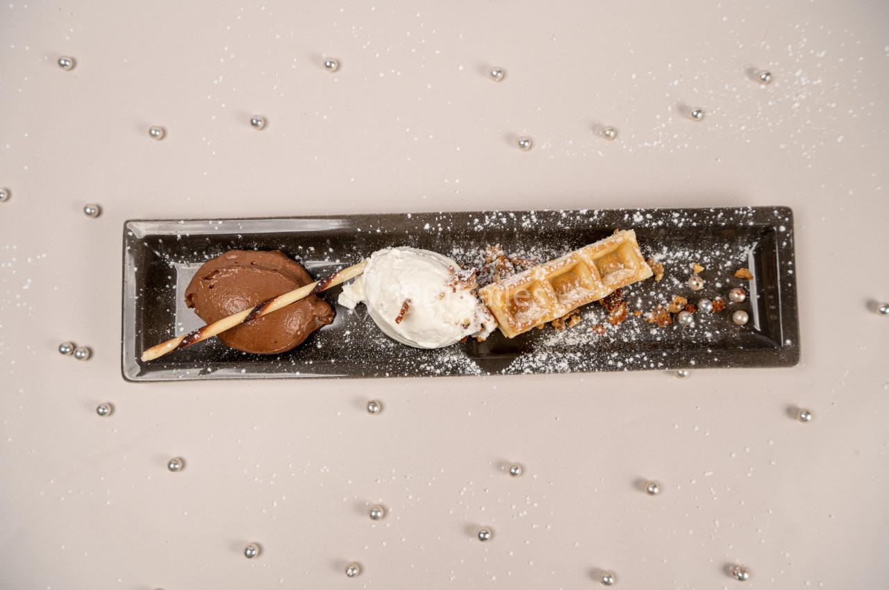 Location salle Donceel (Liège) - Château de Limont #22 Assiette rectangulaire avec boule de glace au chocolat, boule de glace vanille, gaufre, éclats de noisettes et sucre glace.