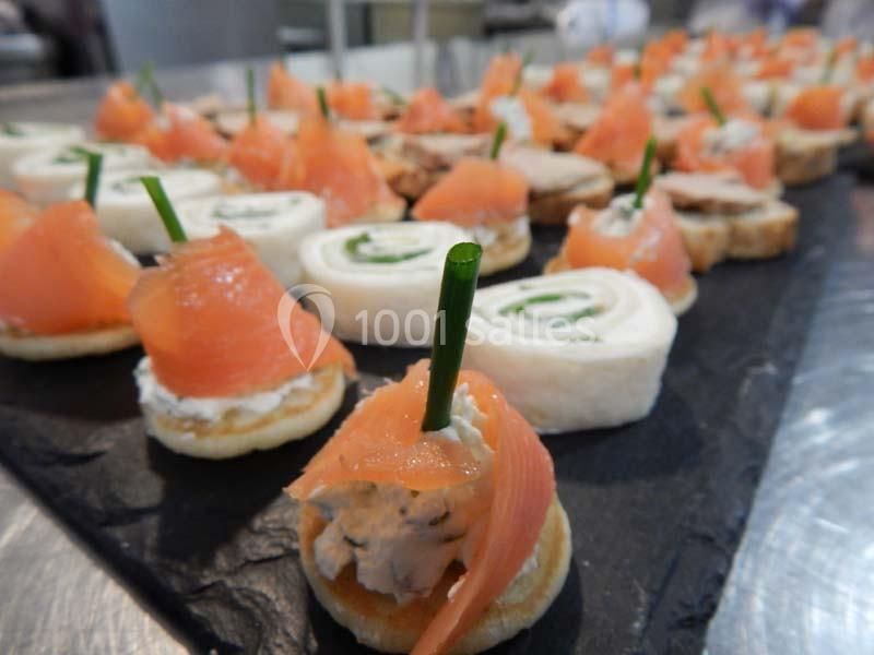 Plateau de canapés variés comprenant des roulés, des blinis au saumon fumé et des garnitures fraîches.