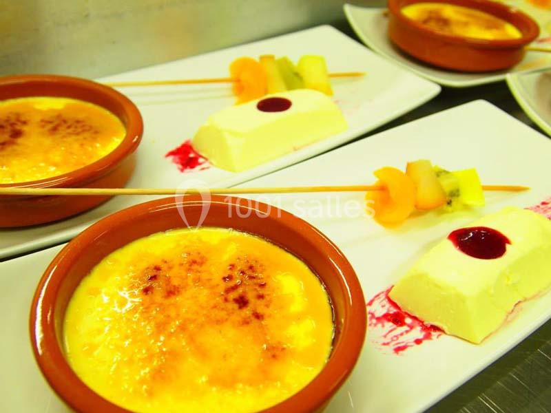 Desserts servis sur assiettes : crèmes brûlées, brochettes de fruits et entremets au coulis rouge.