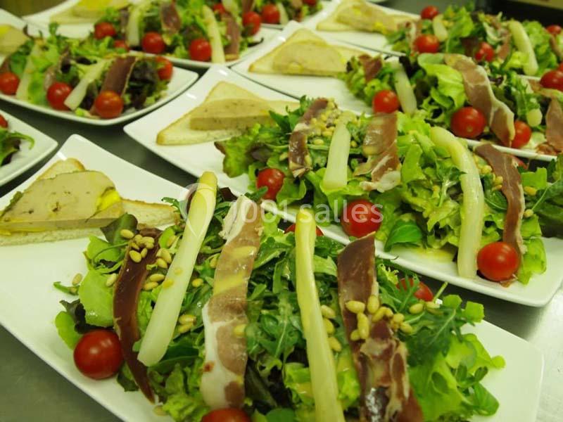 Assiettes de salade garnies de magret de canard, asperges, foie gras, tomates cerises et pignons de pin.