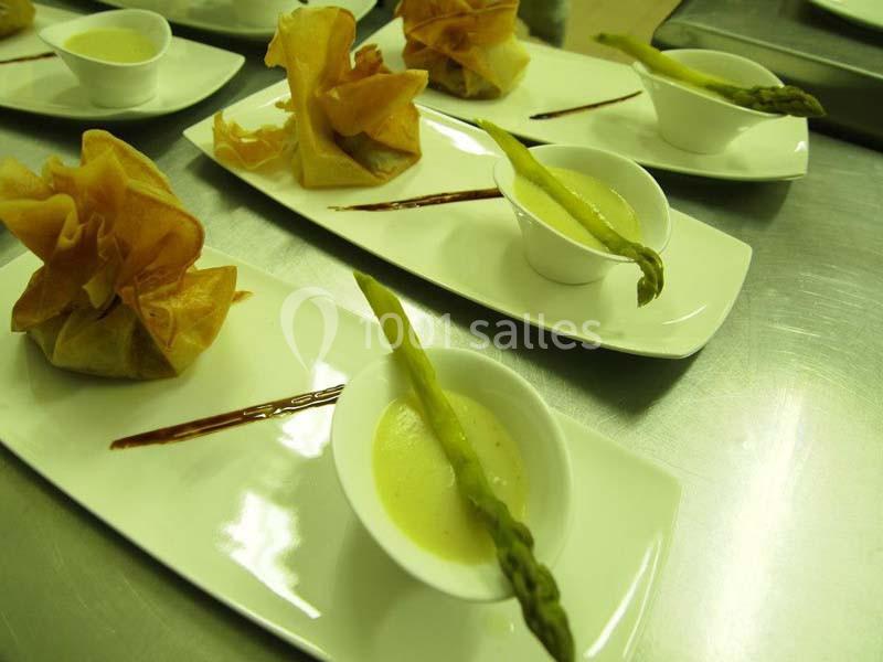 Assiettes élégantes avec croustillants en pâte, asperges et sauce servie dans des coupelles blanches.