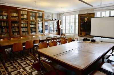 Miniature Location salle Paris 14 (Paris) - Cité Universitaire – Fondation Biermans-Lapôtre #25 Écran de projection blanc dans une petite salle équipée de fauteuils marron et de haut-parleurs muraux.