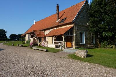 Salle rustique avec murs en pierre et poutres apparentes, aménagée avec tables hautes, canapés et décorations simples.
