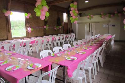 Salle rustique avec murs en pierre et poutres apparentes, aménagée avec tables hautes, canapés et décorations simples.