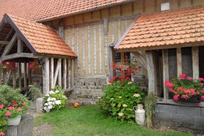 Salle rustique avec murs en pierre et poutres apparentes, aménagée avec tables hautes, canapés et décorations simples.