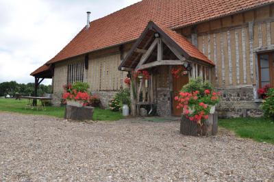 Salle rustique avec murs en pierre et poutres apparentes, aménagée avec tables hautes, canapés et décorations simples.