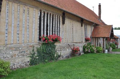 Salle rustique avec murs en pierre et poutres apparentes, aménagée avec tables hautes, canapés et décorations simples.