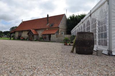 Salle rustique avec murs en pierre et poutres apparentes, aménagée avec tables hautes, canapés et décorations simples.