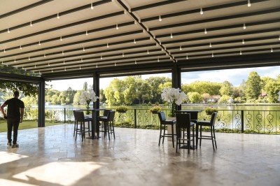 Cérémonie de mariage en plein air avec des invités assis, un couple avançant vers une arche décorée.