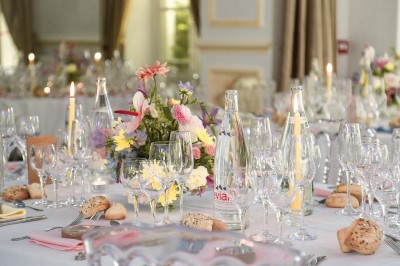 Cérémonie de mariage en plein air avec des invités assis, un couple avançant vers une arche décorée.
