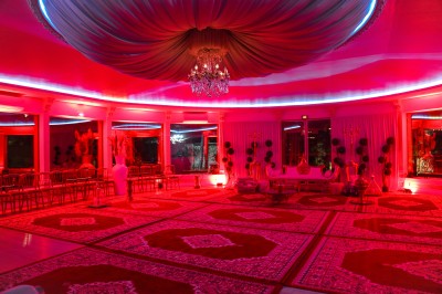 Cérémonie de mariage en plein air avec des invités assis, un couple avançant vers une arche décorée.