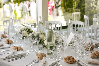 Cérémonie de mariage en plein air avec des invités assis, un couple avançant vers une arche décorée.