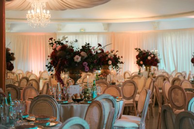 Cérémonie de mariage en plein air avec des invités assis, un couple avançant vers une arche décorée.