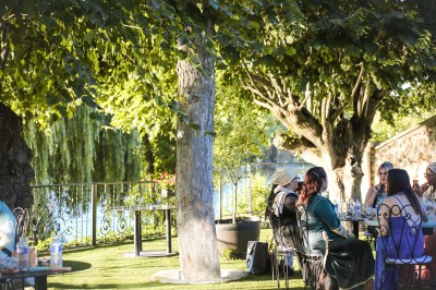 Cérémonie de mariage en plein air avec des invités assis, un couple avançant vers une arche décorée.