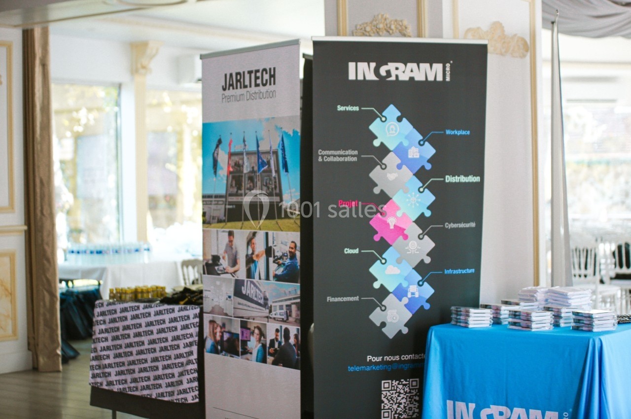 Deux kakémonos promotionnels et une table avec des brochures dans une salle lumineuse.