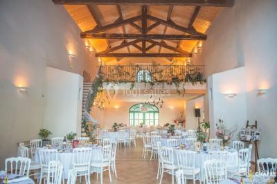 Allée bordée de palmiers éclairés, menant à une fontaine illuminée dans un jardin au crépuscule.