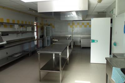 Miniature CUISINE ESPACE DU LAC Cuisine professionnelle avec plan de travail en inox, lave-vaisselle industriel et casiers de rangement colorés.