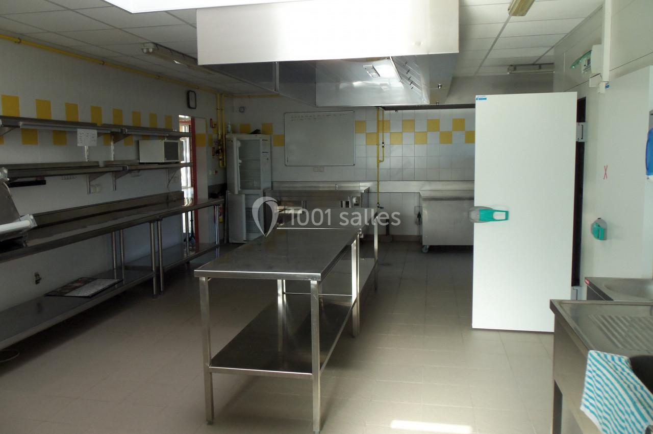 CUISINE ESPACE DU LAC Cuisine professionnelle avec plans de travail en inox, carrelage mural blanc et jaune, et équipements de restauration.