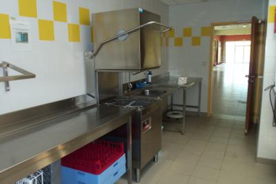 Miniature PLONGE ESPACE DU LAC Cuisine professionnelle avec plan de travail en inox, lave-vaisselle industriel et casiers de rangement colorés.