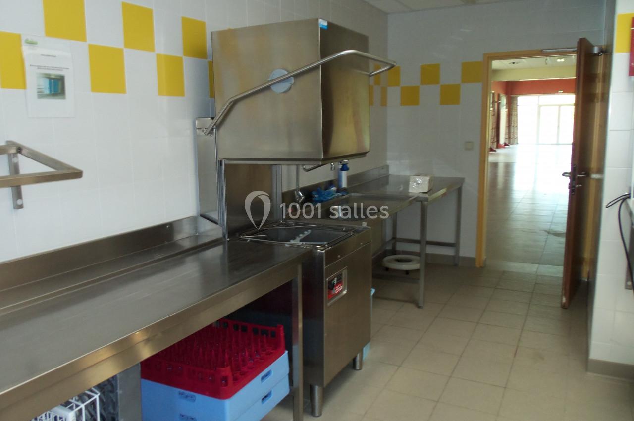PLONGE ESPACE DU LAC Cuisine professionnelle avec plan de travail en inox, lave-vaisselle industriel et casiers de rangement colorés.