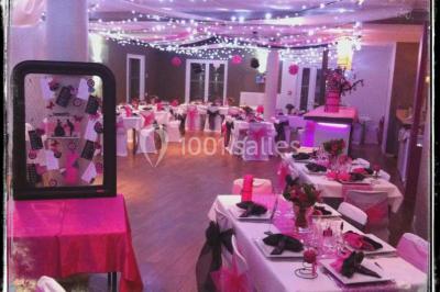 Château gonflable blanc installé sur une surface gravillonnée, entouré de végétation et de mobilier de jardin.