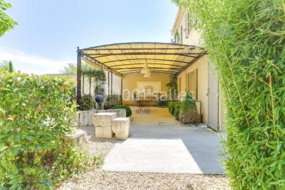Château gonflable blanc installé sur une surface gravillonnée, entouré de végétation et de mobilier de jardin.