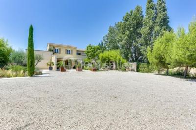 Château gonflable blanc installé sur une surface gravillonnée, entouré de végétation et de mobilier de jardin.