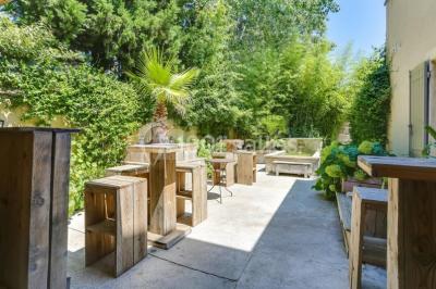Château gonflable blanc installé sur une surface gravillonnée, entouré de végétation et de mobilier de jardin.