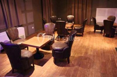 Château gonflable blanc installé sur une surface gravillonnée, entouré de végétation et de mobilier de jardin.