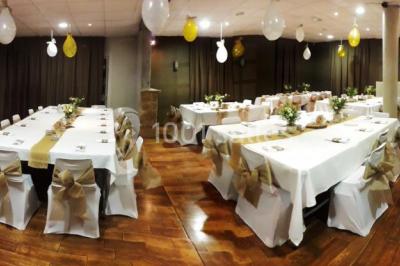 Château gonflable blanc installé sur une surface gravillonnée, entouré de végétation et de mobilier de jardin.