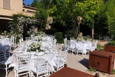 Château gonflable blanc installé sur une surface gravillonnée, entouré de végétation et de mobilier de jardin.