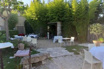 Château gonflable blanc installé sur une surface gravillonnée, entouré de végétation et de mobilier de jardin.