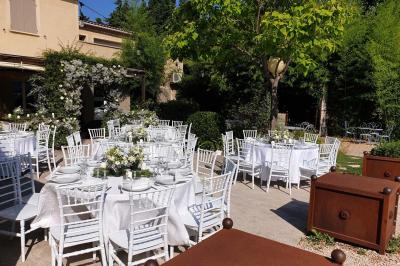 Château gonflable blanc installé sur une surface gravillonnée, entouré de végétation et de mobilier de jardin.