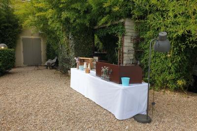 Château gonflable blanc installé sur une surface gravillonnée, entouré de végétation et de mobilier de jardin.