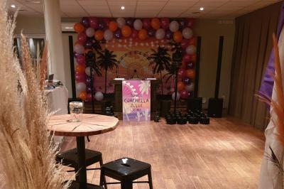 Château gonflable blanc installé sur une surface gravillonnée, entouré de végétation et de mobilier de jardin.