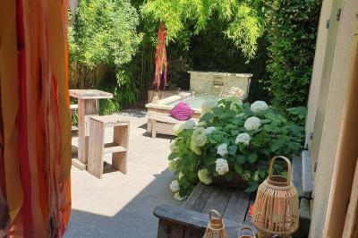 Château gonflable blanc installé sur une surface gravillonnée, entouré de végétation et de mobilier de jardin.
