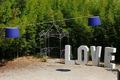 Château gonflable blanc installé sur une surface gravillonnée, entouré de végétation et de mobilier de jardin.