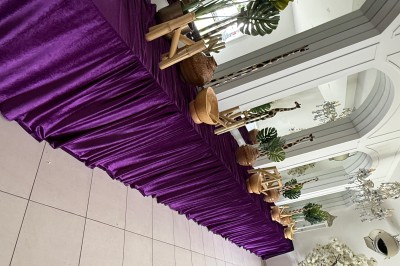 Miniature Location salle Vitry-sur-Seine (Val-de-Marne) - Les Salons Lyna #21 Table décorée d'une nappe violette avec des plantes, paniers en osier et éléments en bois, dans une salle lumineuse.