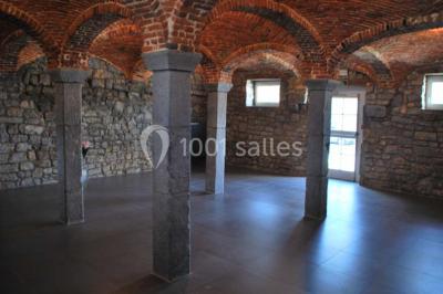 Miniature Location salle Ciney (Province de Namur) - Le Domaine d'Achêne #7 Voûte en briques rouges avec piliers en pierre, sol carrelé gris et mur en pierre apparente.