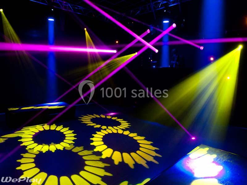 Location salle Ciney (Province de Namur) - Le Domaine d'Achêne #13 Jeux de lumières colorées projetés dans une salle sombre avec des motifs circulaires au sol.