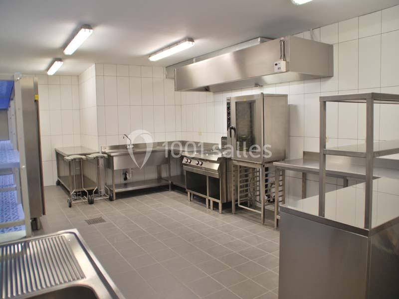 Location salle Ciney (Province de Namur) - Le Domaine d'Achêne #15 Cuisine professionnelle avec équipements en inox, comprenant un four, des plans de travail et un évier, dans un espace…