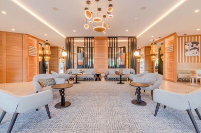 Miniature Location salle Saint-Laurent-du-Var (Alpes-Maritimes) - Playamesa #22 Chambre d'hôtel lumineuse avec lit double, bureau, fauteuil, grandes fenêtres et vue sur un balcon.