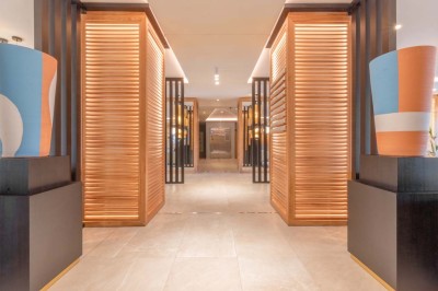 Miniature Location salle Saint-Laurent-du-Var (Alpes-Maritimes) - Playamesa #26 Chambre d'hôtel lumineuse avec lit double, bureau, fauteuil, grandes fenêtres et vue sur un balcon.