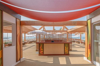 Miniature Location salle Saint-Laurent-du-Var (Alpes-Maritimes) - Playamesa #37 Chambre d'hôtel lumineuse avec lit double, bureau, fauteuil, grandes fenêtres et vue sur un balcon.