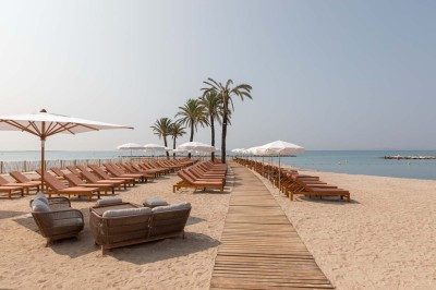 Miniature Location salle Saint-Laurent-du-Var (Alpes-Maritimes) - Playamesa #5 Chambre d'hôtel lumineuse avec lit double, bureau, fauteuil, grandes fenêtres et vue sur un balcon.