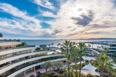 Miniature Location salle Saint-Laurent-du-Var (Alpes-Maritimes) - Playamesa #20 Chambre d'hôtel lumineuse avec lit double, bureau, fauteuil, grandes fenêtres et vue sur un balcon.