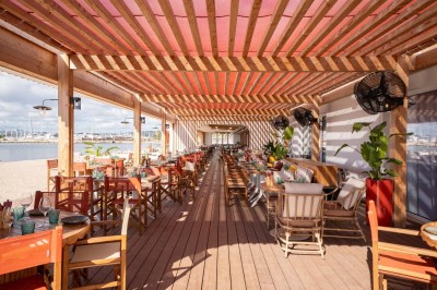 Miniature Location salle Saint-Laurent-du-Var (Alpes-Maritimes) - Playamesa #2 Chambre d'hôtel lumineuse avec lit double, bureau, fauteuil, grandes fenêtres et vue sur un balcon.