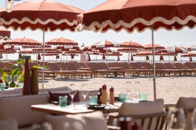 Miniature Location salle Saint-Laurent-du-Var (Alpes-Maritimes) - Playamesa #7 Chambre d'hôtel lumineuse avec lit double, bureau, fauteuil, grandes fenêtres et vue sur un balcon.