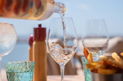 Miniature Location salle Saint-Laurent-du-Var (Alpes-Maritimes) - Playamesa #13 Chambre d'hôtel lumineuse avec lit double, bureau, fauteuil, grandes fenêtres et vue sur un balcon.